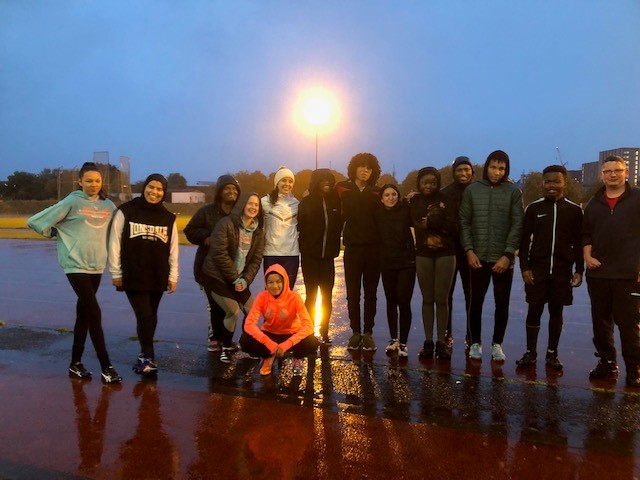 Stef Reid and a group of young people on a running track