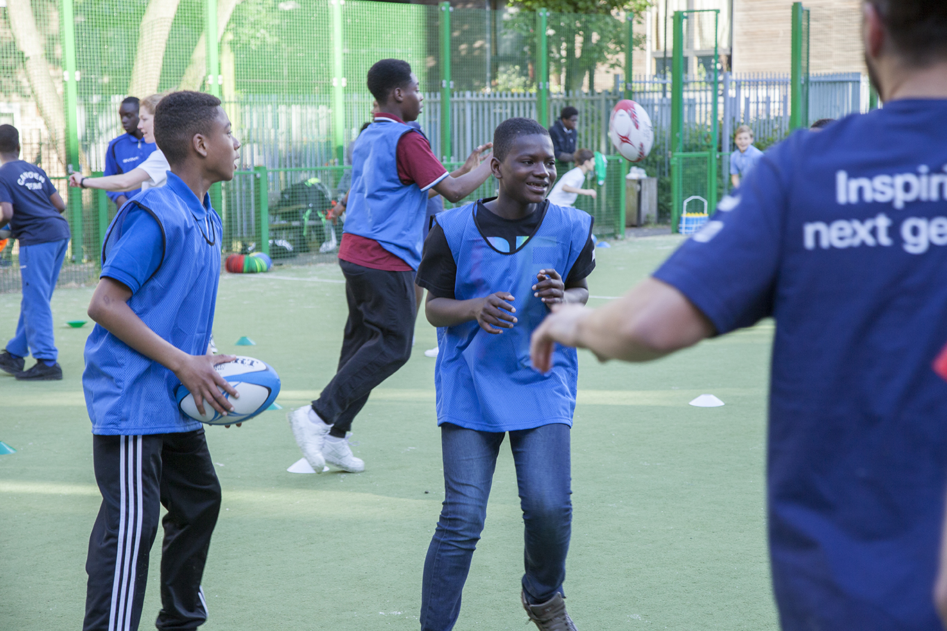 Two young boys smiling wearing football bibs
