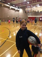 girl holding a basket ball in a sports hall