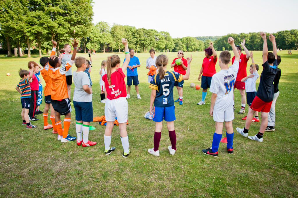 children playing a circle game on a sunny field