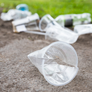 plastic cups and bottles littering with grass in background