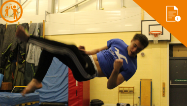young man in mid air doing a back flip in a gym. Orange embedded in the community information graphic, orange disability inclusion graphic