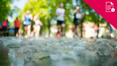 blurred people in sports clothing in background, plastic litter in foreground. Red delivery information graphic in corner