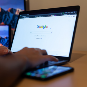 hands using a laptop with google open on screen