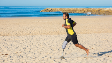 Amputee man running on a beach